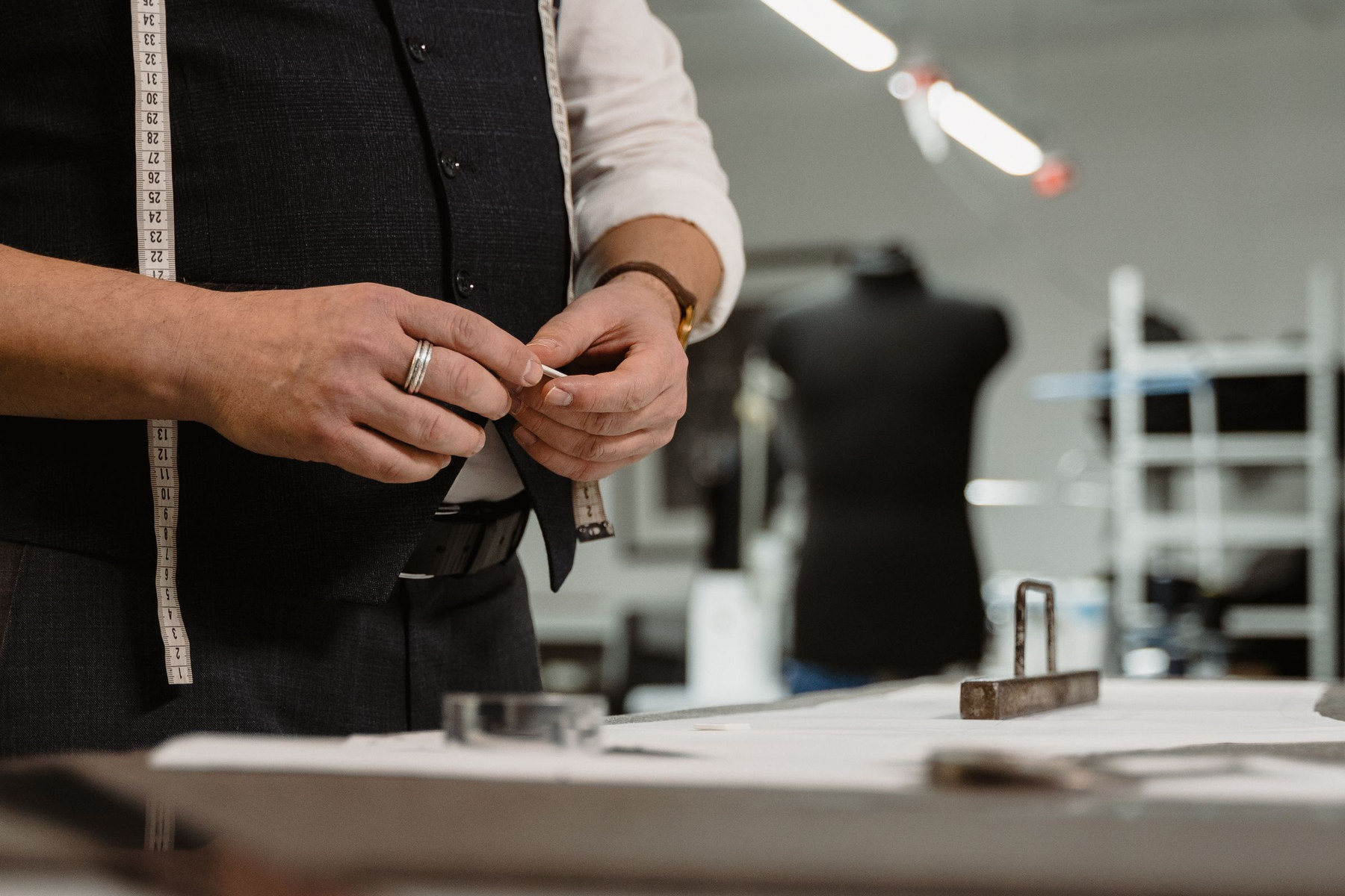 A tailor pinning cloth on a jacket front