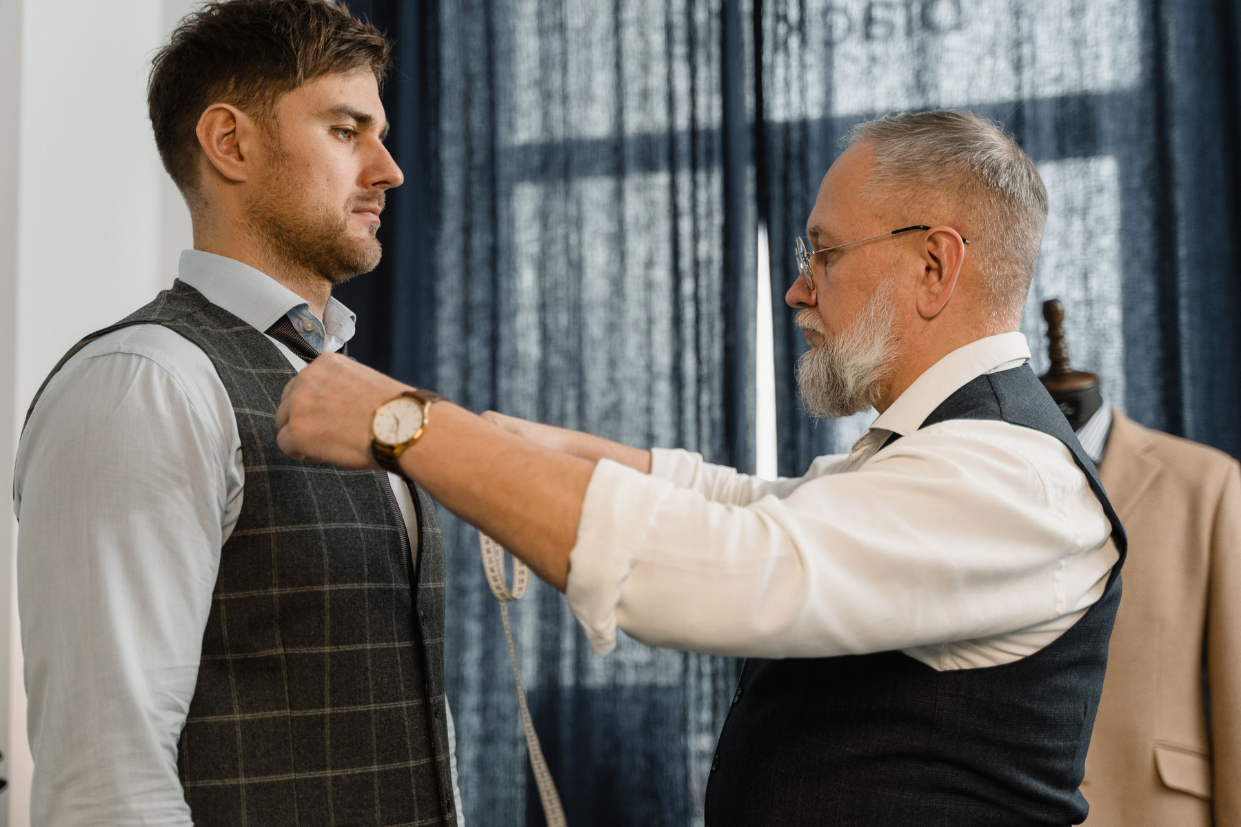 A cutter taking a measurement during a fitting